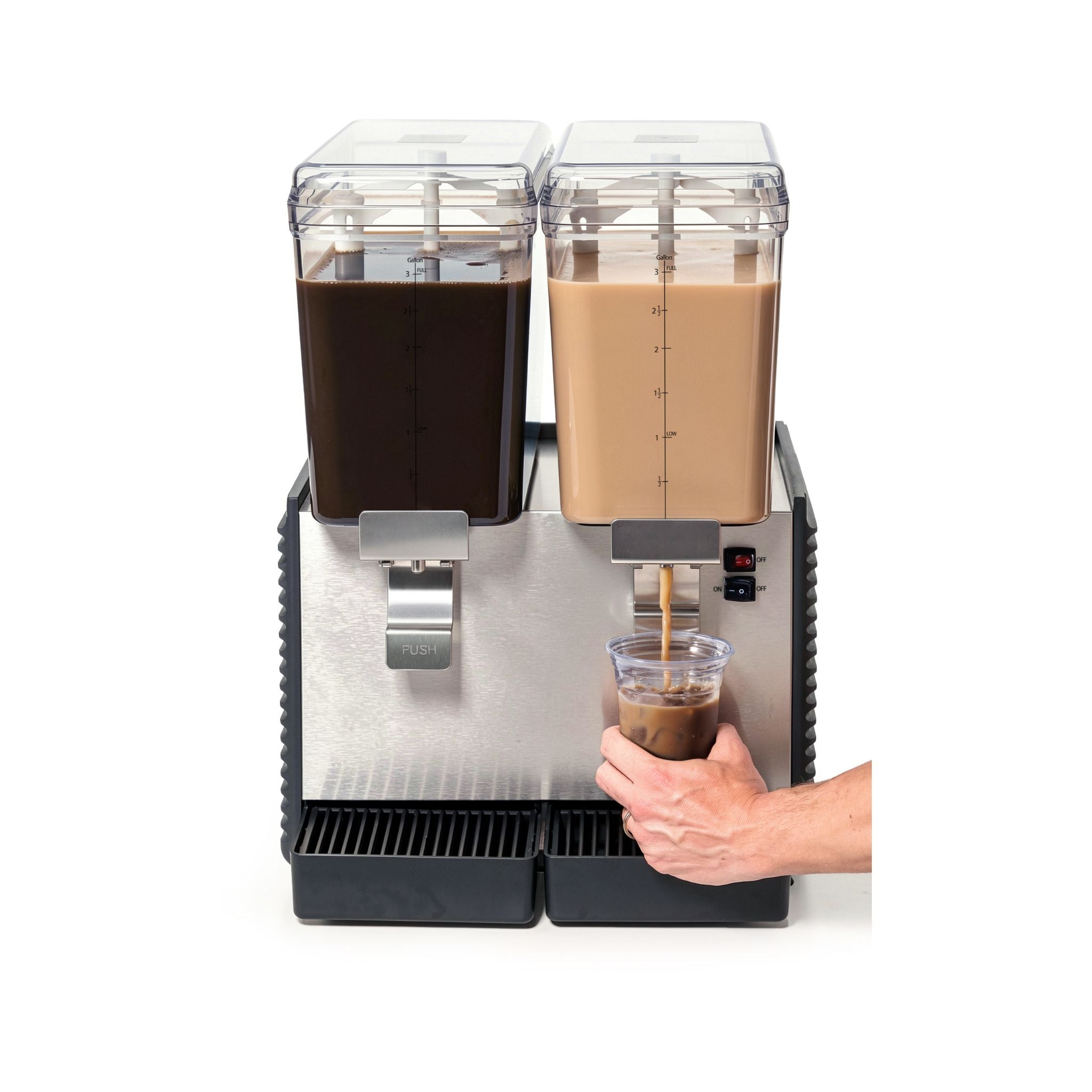 A stainless steel beverage dispenser with two clear drink tanks, one filled with dark coffee and the other with milk, shown with a hand holding a cup under the spout.