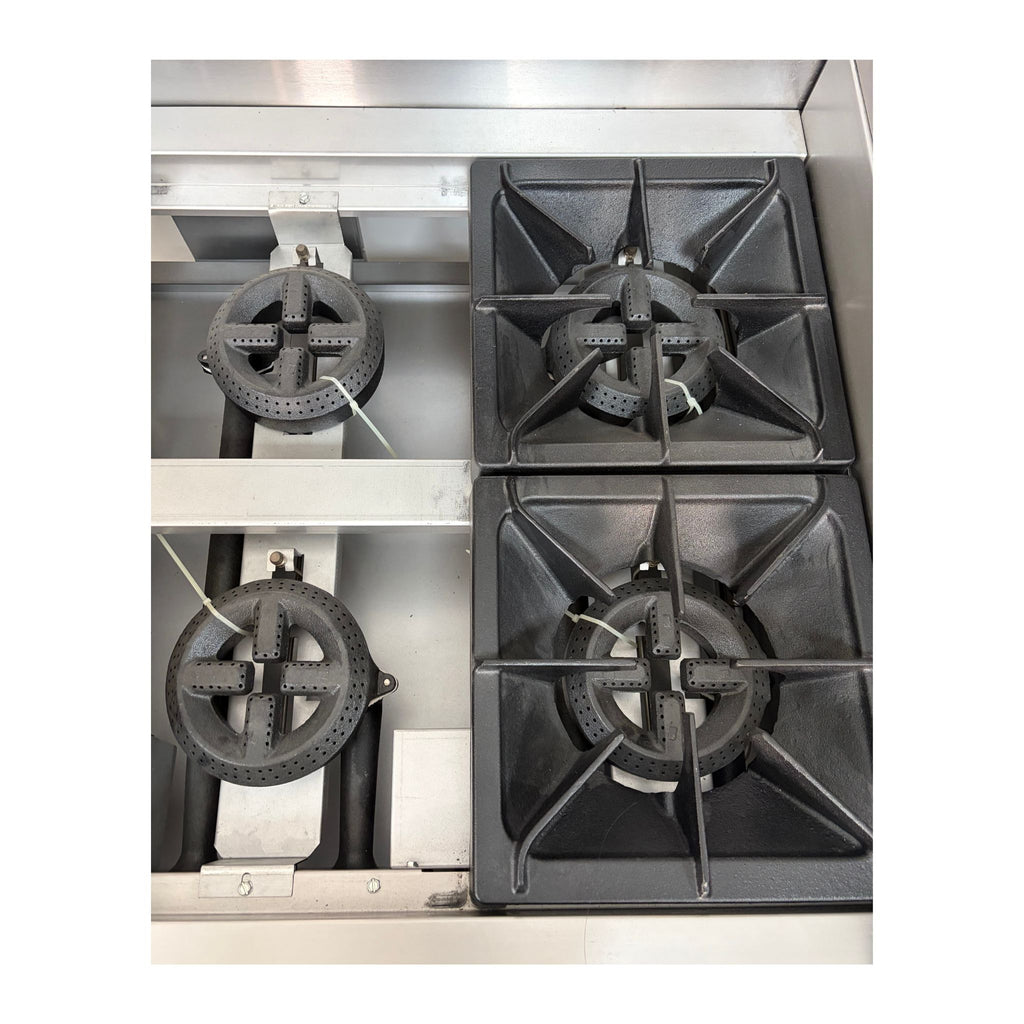 Three gas stove cast iron burners on a metallic surface