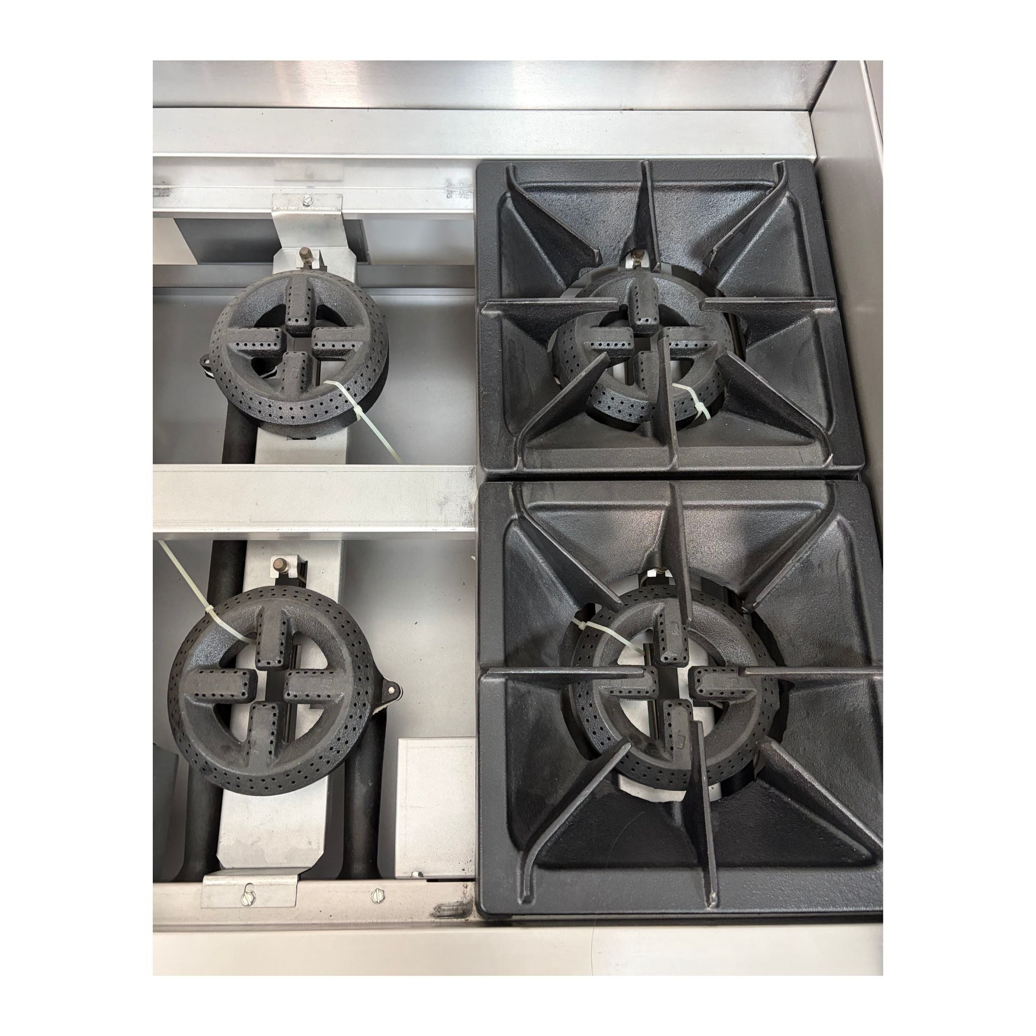 Three gas stove cast iron burners on a metallic surface