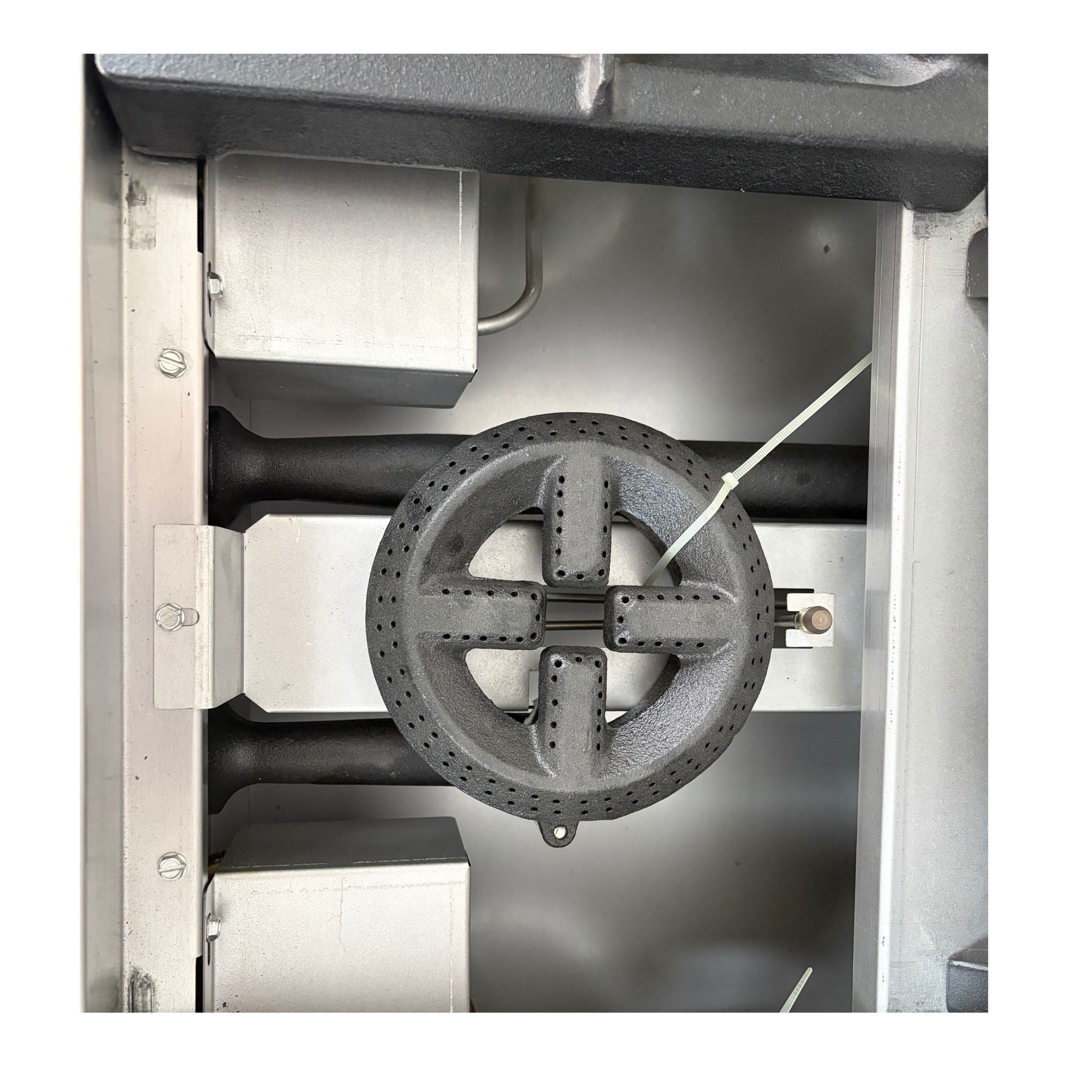 A close-up view of a circular cast iron burner assembly or stove component inside a metallic appliance or machine housing.