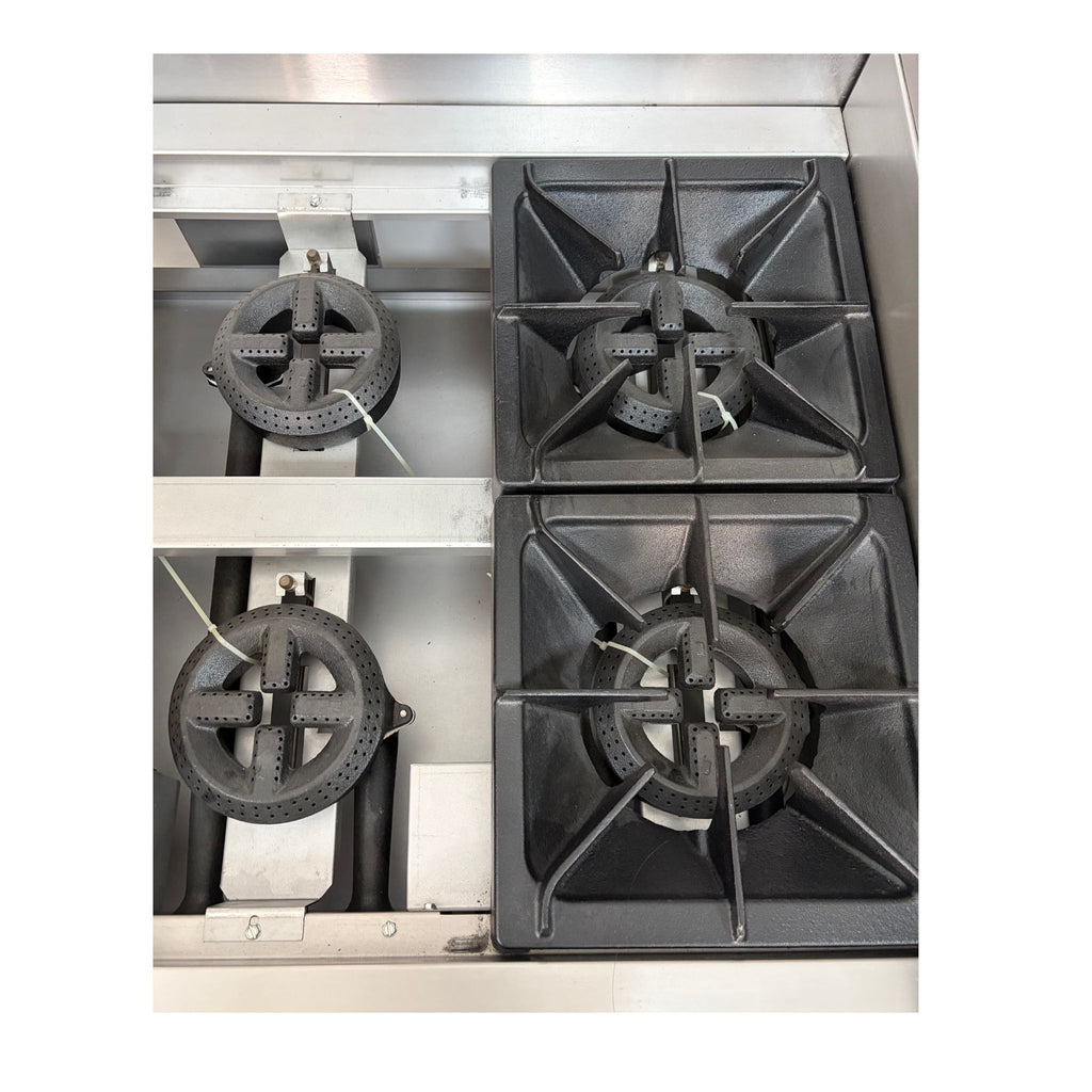 A top-down view of a stainless steel gas range showing two black cast iron burner grates on the right and two burner assemblies on the left.