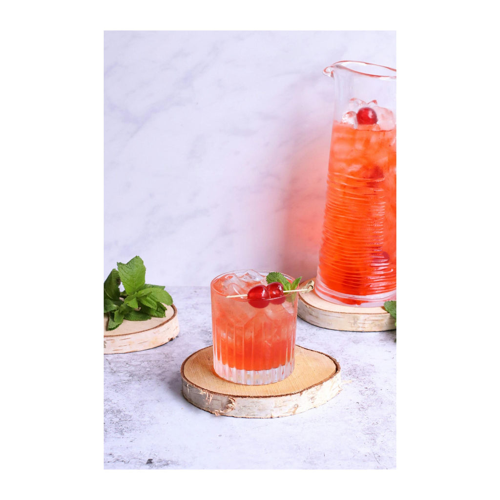 noriota nui15nopss indoor outdoor ice machine, nugget ice, two cocktails with cherries and mint leaves on wooden coasters against a light background 